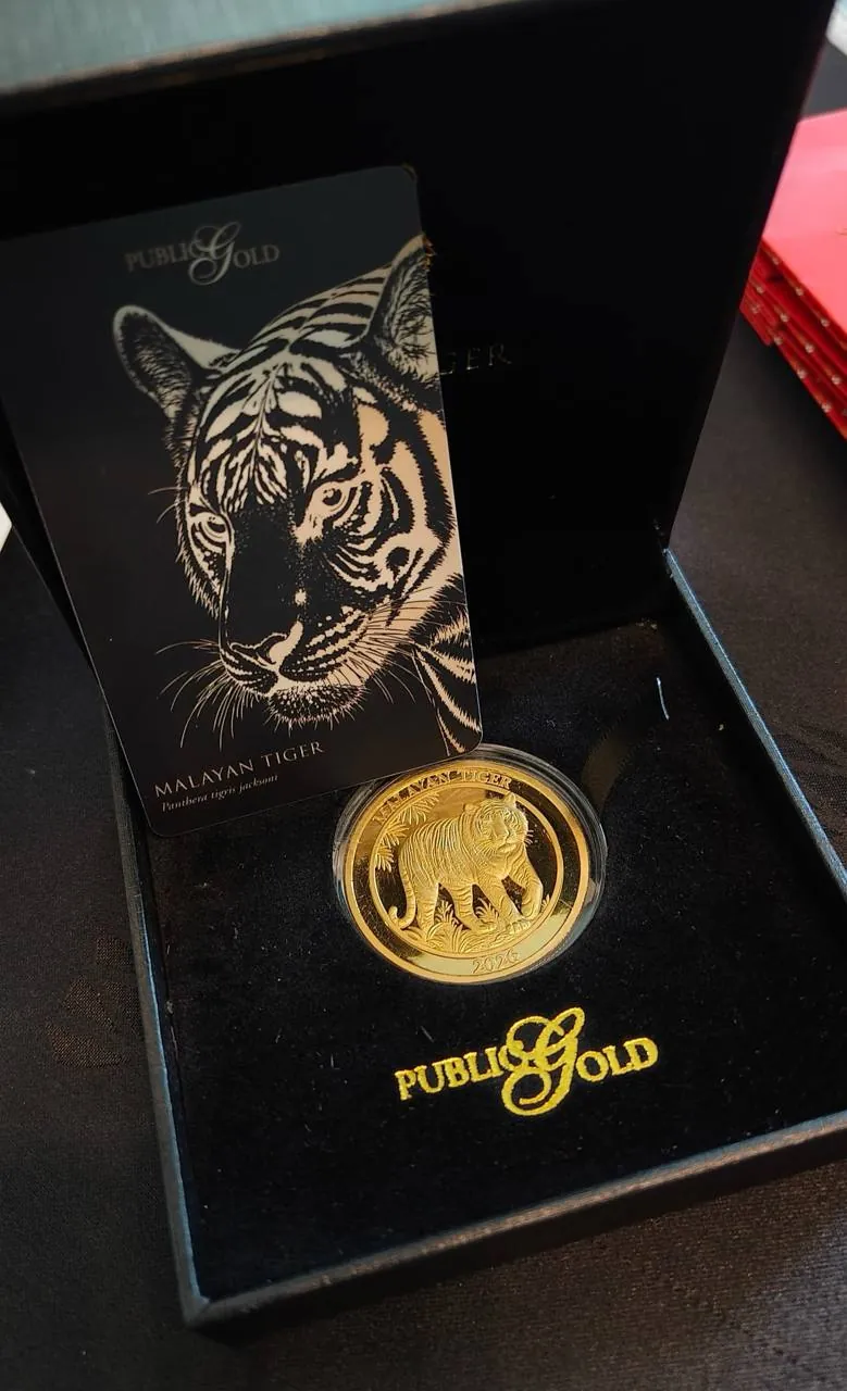 Syiling emas Malayan Tiger Public Gold di dalam kotak persembahan hitam sebagai contoh simpanan emas fizikal untuk pemula
