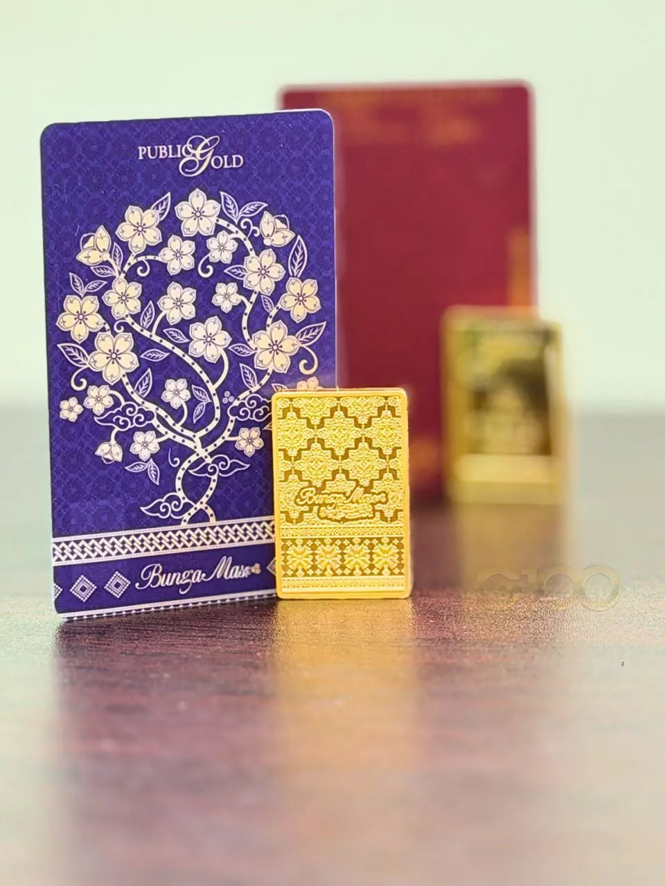 Kad gold certificate Public Gold bersama kepingan gold bar 999.9 di atas meja sebagai rujukan harga emas semasa